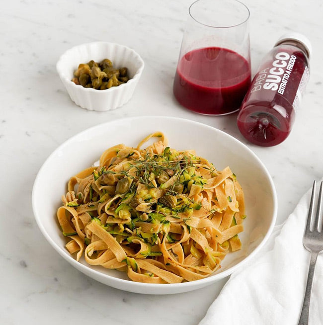 Piatto di pasta con verdure ed estratto Babasucco